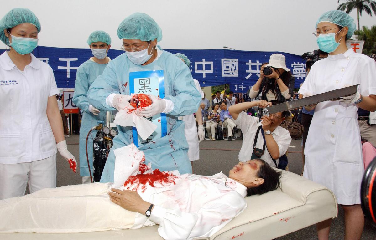 Falun Gong practitioners during a reenactment of the CCP’s practice of forced organ harvesting from Falun Gong practitioners, during a rally in Taipei, Taiwan, on April 23, 2006. (Patrick Lin/AFP via Getty Images)