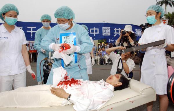  Falun Gong practitioners during a reenactment of the Chinese Communist Party's practice of forced organ harvesting from Falun Gong practitioners, during a rally in Taipei, Taiwan, on April 23, 2006. (Patrick Lin/AFP via Getty Images)