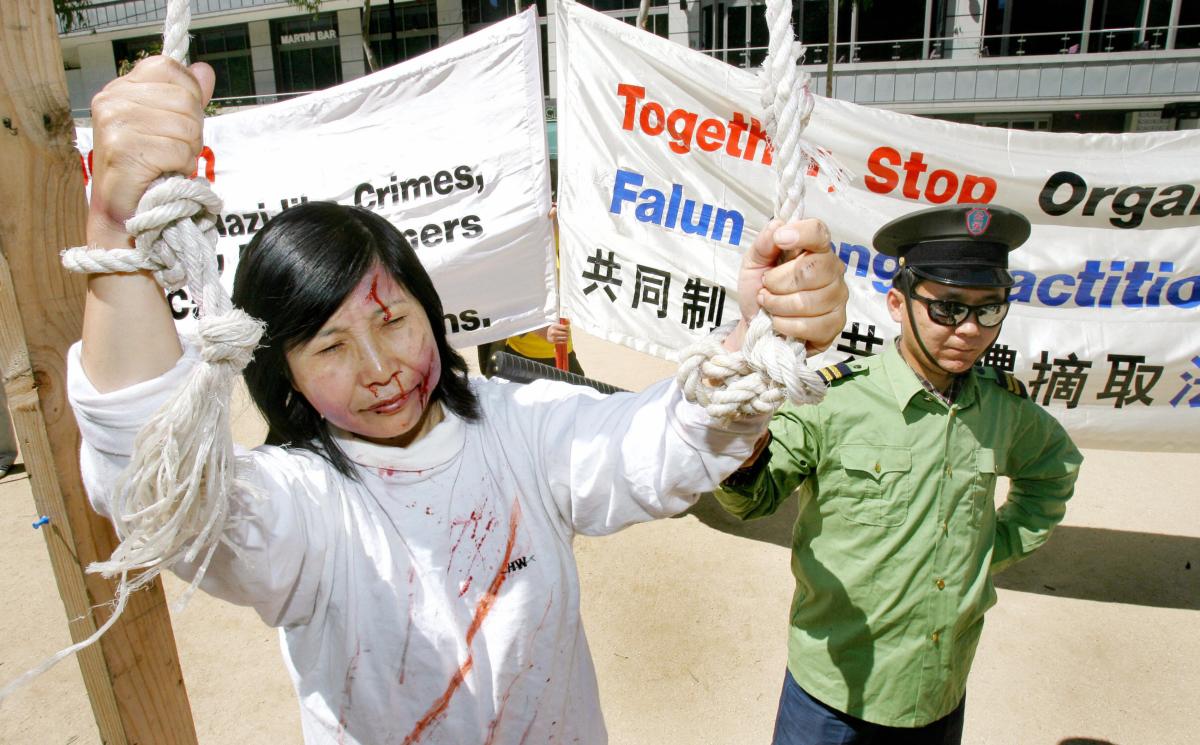 Falun Gong practitioners during a re-enactment depicting the persecution of practitioners in China, in Melbourne, Australia, on Nov. 17, 2006. (WILLIAM WEST/AFP via Getty Images)