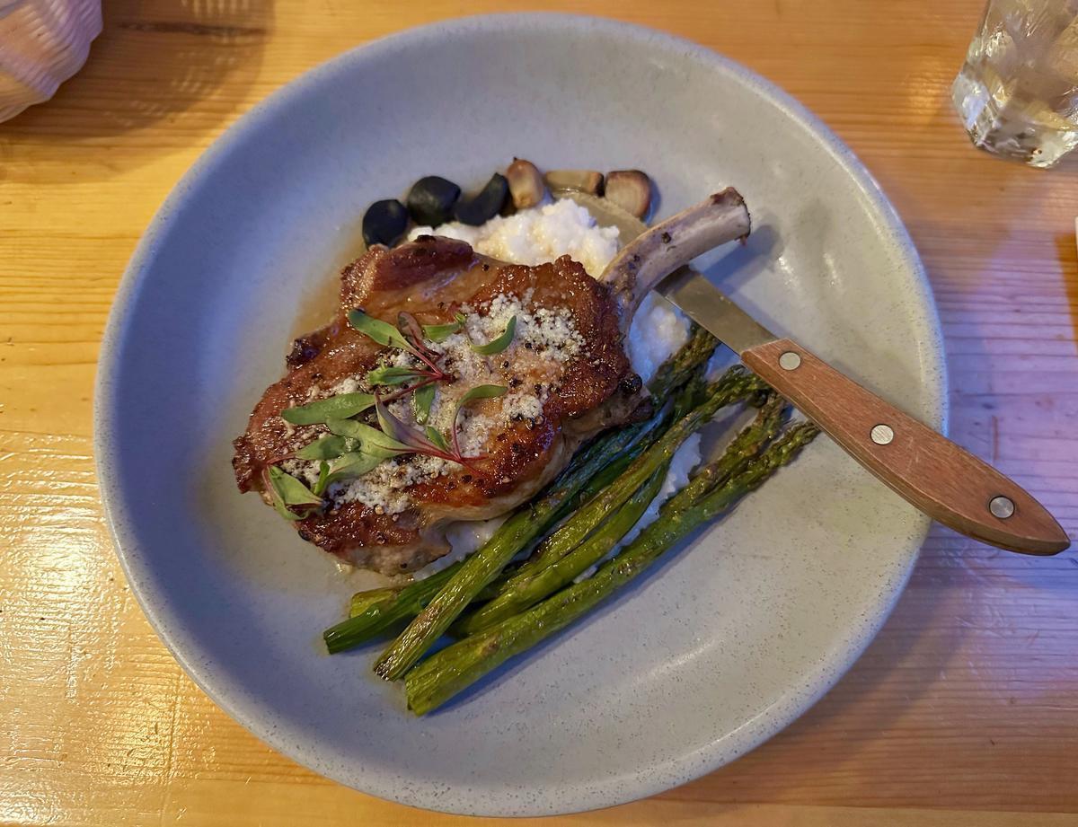 The Camus Room at Wallowa Lake Lodge specializes in American steakhouse-style fare, like this cast iron-seared pork chop served with cheesy rice and local asparagus. (Jackie Varriano/The Seattle Times/TNS)