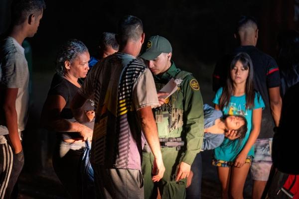 Illegal immigrants wait to be taken by Border Patrol to a processing facility to begin their asylum-seeking process in Eagle Pass, Texas, on June 25, 2023. (Suzanne Cordeiro/AFP via Getty Images)