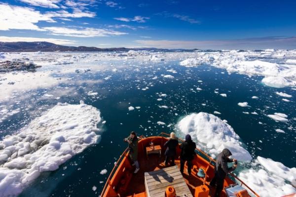 Visitors on a sightseeing vessel watch icebergs floating in Disko Bay, Ilulissat, western Greenland, on June 28, 2022. (Odd Andersen/AFP via Getty Images)