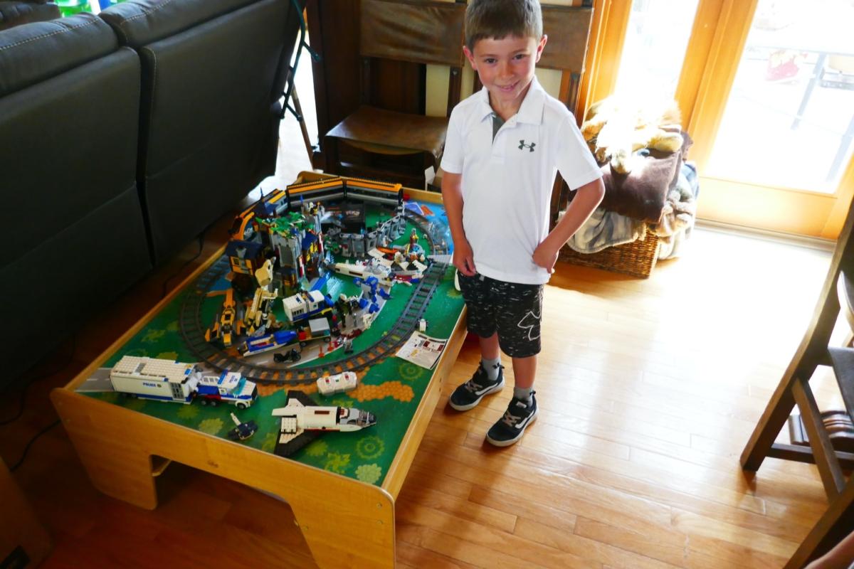 H.N. stands next to some of his toys at his house in Scotts Valley, Calif., on July 16, 2023. (Steve Ispas/The Epoch Times)