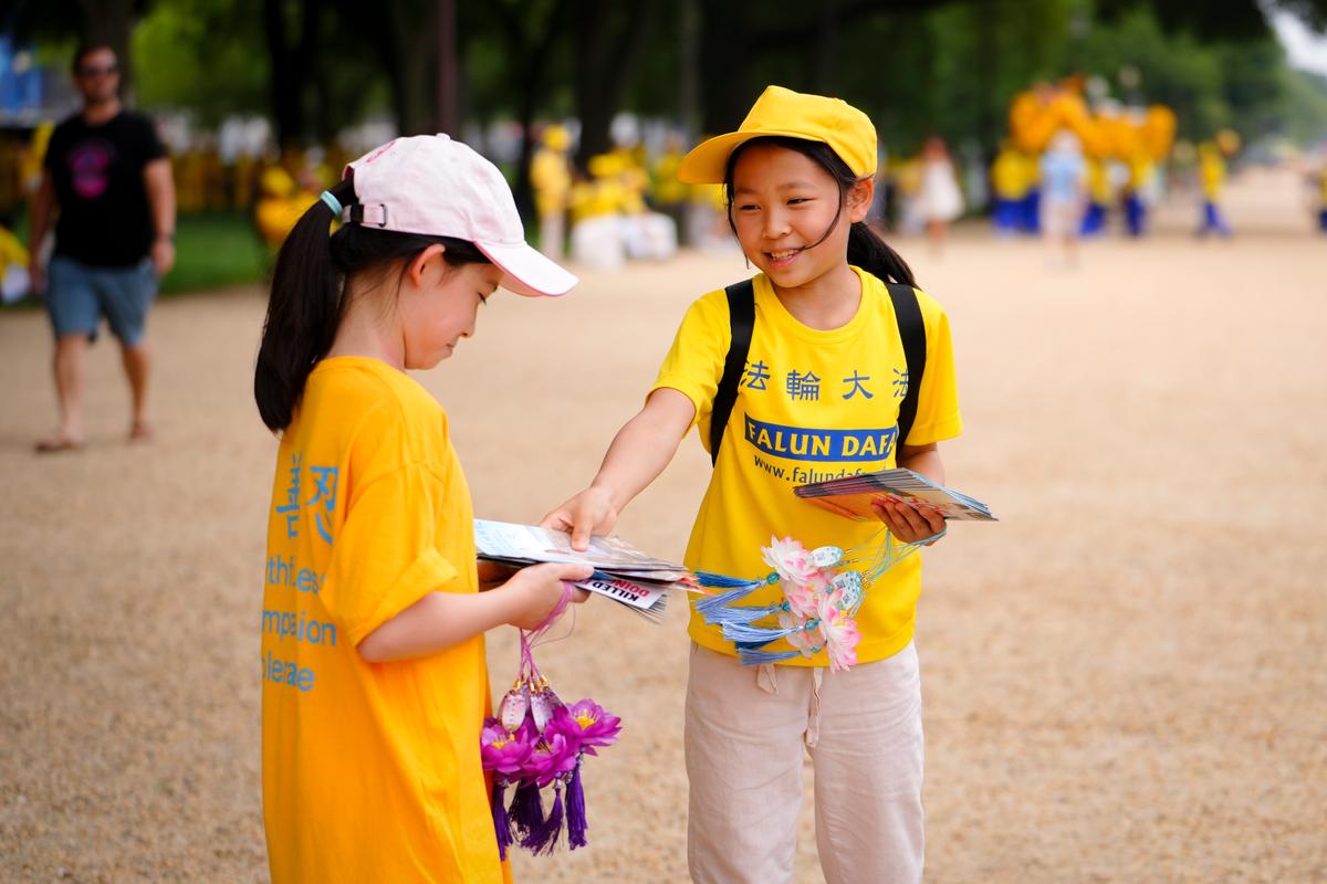 Children play during a Falun Gong rally marking the 24th anniversary of the persecution of the spiritual discipline in China by the Chinese Communist Party in Washington, on July 20, 2023. (Madalina Vasiliu/The Epoch Times)