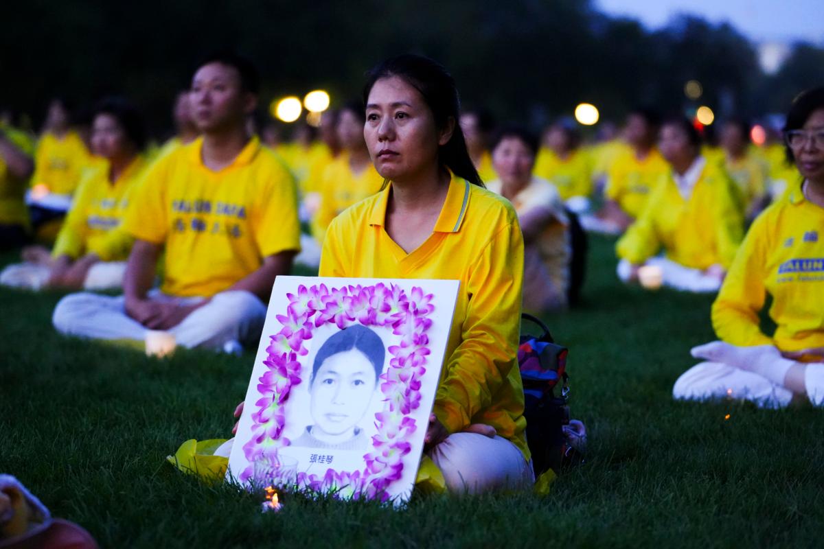 Falun Gong adherents hold candles during a candlelight vigil in memory of Falun Gong practitioners who passed away due to the Chinese Communist Party’s 24 years of persecution, at the National Mall in Washington on July 20, 2023. (Madalina Vasiliu/The Epoch Times)