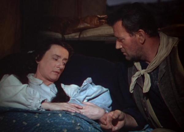A dying mother (Mildred Natwick) gives her newborn to outlaw Bob (John Wayne), in “3 Godfathers.” (Metro-Goldwyn-Mayer)