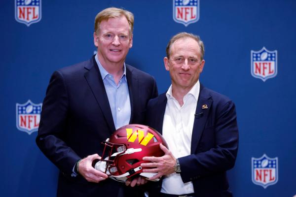 NFL Commissioner Roger Goodell presents new Washington Commanders owner Josh Harris with a team helmet after a special meeting to vote on approval of the sale of the team in Bloomington, Minn., on July 20, 2023. (Bruce Kluckhohn/AP Photo)