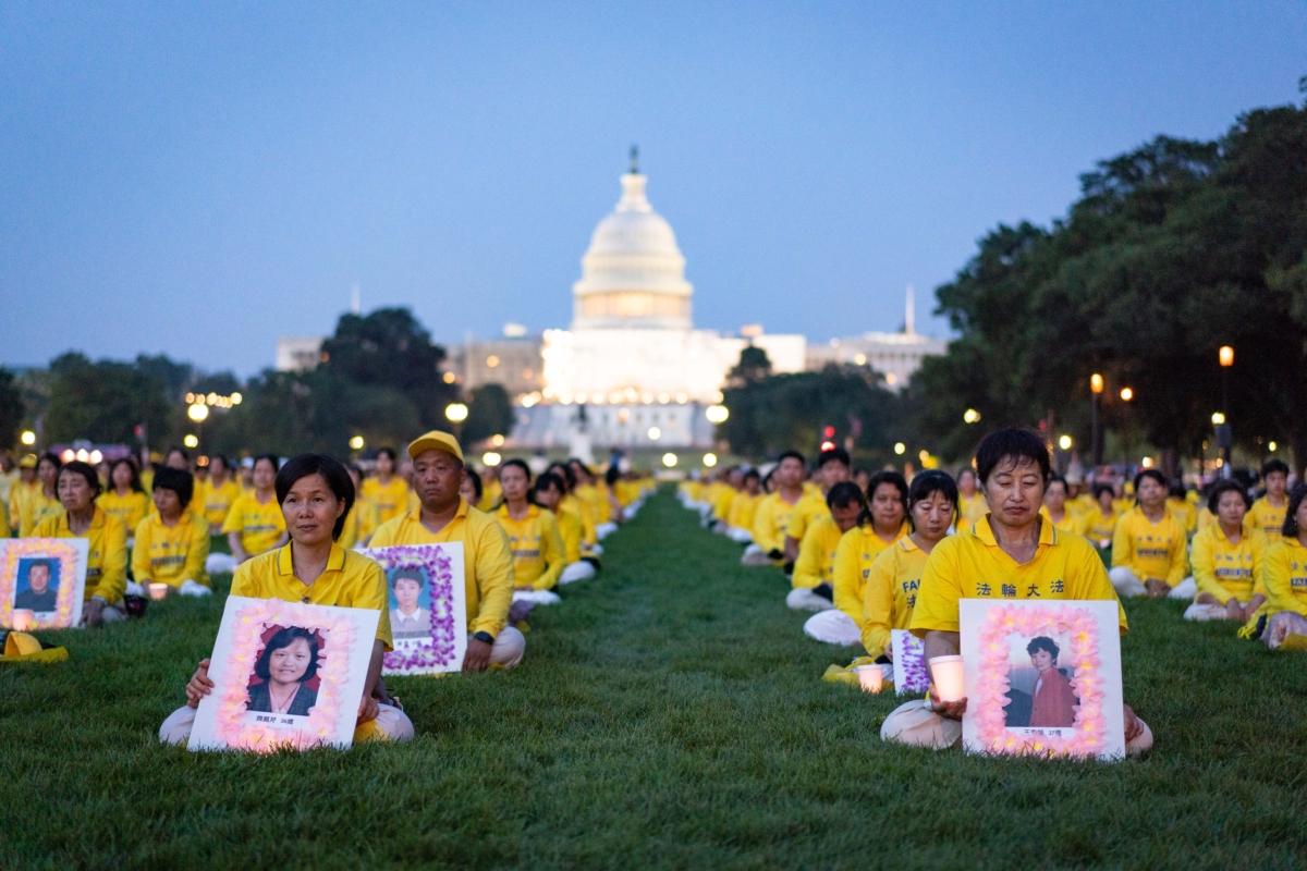 Falun Gong adherents hold candles during a candlelight vigil in memory of Falun Gong practitioners who passed away due to the Chinese Communist Party’s 24 years of persecution, at the National Mall in Washington on July 20, 2023. (Samira Bouaou/The Epoch Times)