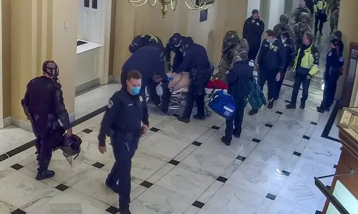 Paramedics stop the gurney carrying Rosanne Boyland near the House Wing Door at the U.S. Capitol and move her to the floor to continue CPR on Jan. 6, 2021. (U.S. Capitol Police/Screenshot via The Epoch Times)