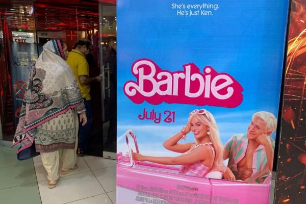 Moviegoers walk past the poster of the movie "Barbie" at a cineplex in Islamabad on July 21, 2023. (Aamir Qureshi/AFP via Getty Images)
