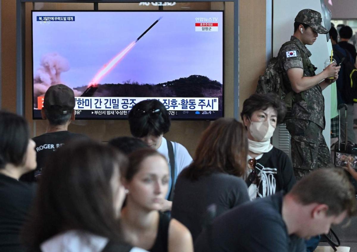 A South Korean soldier (R) stands next to a television screen showing a news broadcast with file footage of a North Korean missile test, at a railway station in Seoul, South Korea, on July 22, 2023. (Jung Yeon-Je/AFP via Getty Images)