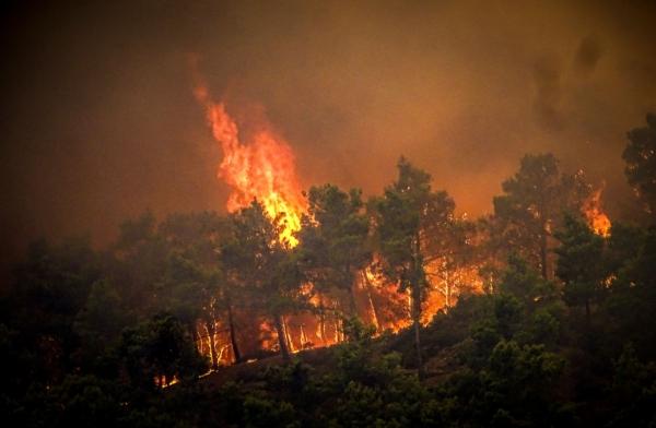 Flames rise during a forest fire on the island of Rhodes, Greece, on July 22, 2023. (Argyris Mantikos/Eurokinissi via AP)