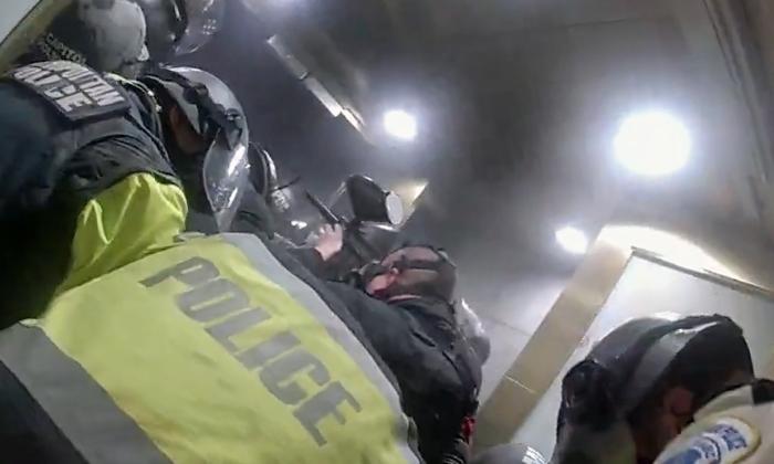A police officer fires pepper balls into the densely packed crowd of protesters in the Lower West Terrace tunnel at the U.S. Capitol on Jan. 6, 2021. (Metropolitan Police Department/Screenshot via The Epoch Times)