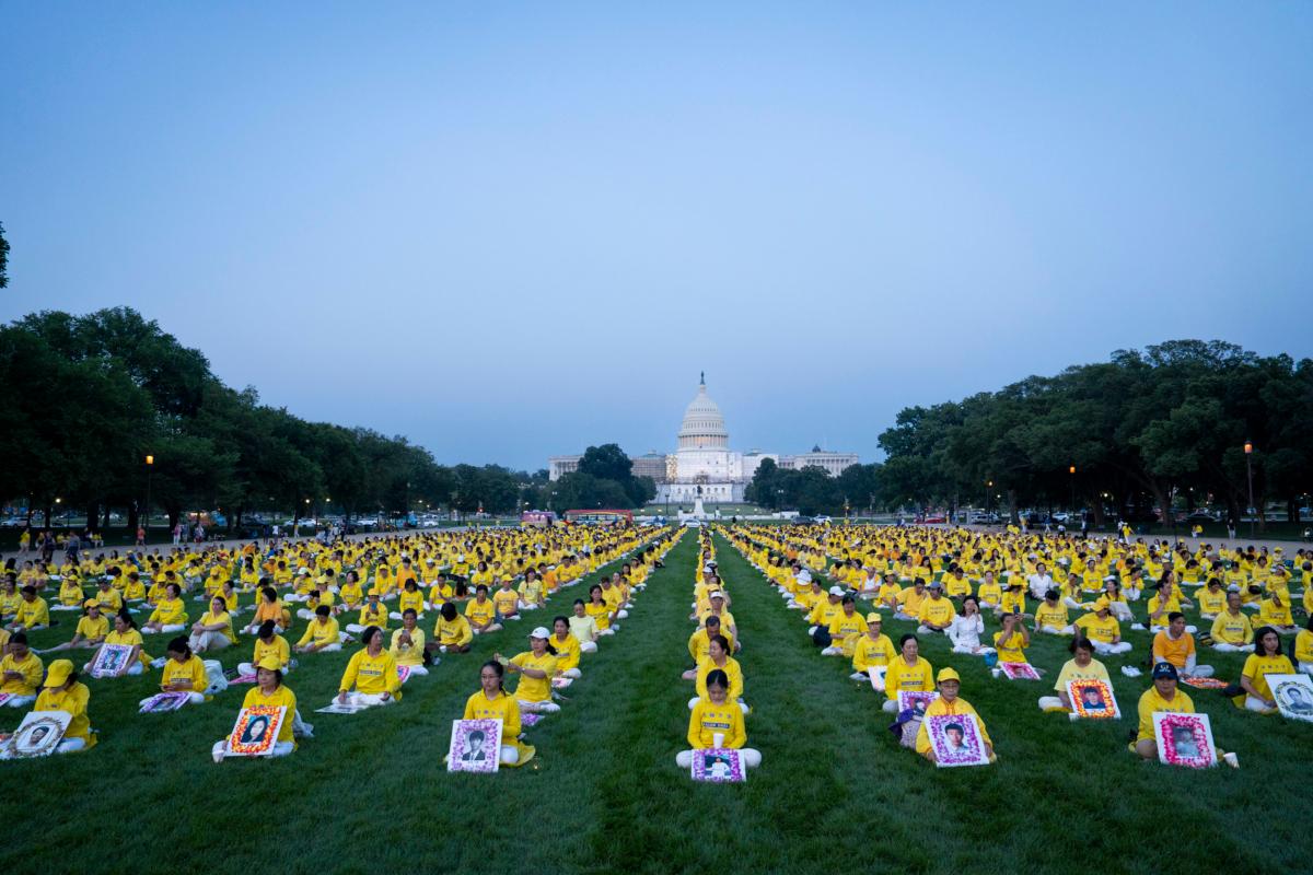Falun Gong adherents gather at a candlelight vigil in memory of Falun Gong practitioners who passed away because of the Chinese Communist Party's ongoing 24-year persecution of the spiritual discipline at the National Mall in Washington on July 20, 2023. (Madalina Vasiliu/The Epoch Times)