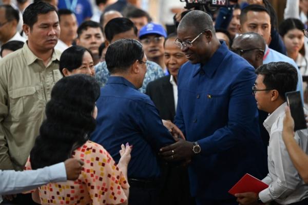 Cambodia's Prime Minister Hun Sen (center left) shakes hands with Guinea-Bissau's Prime Minister Nuno Gomes Nabiam after Hun Sen cast his vote at a polling station in Kandal province during the general elections on July 23, 2023. (TANG CHHIN SOTHY/AFP via Getty Images)