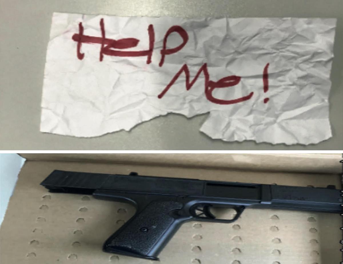 The hand-written sign (above) and BB gun (below) allegedly found in the 61-year-old suspect's car. (Courtesy of Department of Justice)
