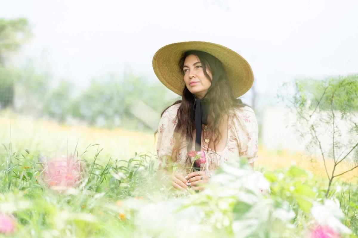 Shiva Rose outside her home in rural Texas, where she keeps bees and grows her own food. (Jamie Barker)