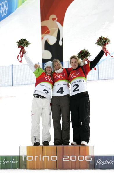 Switzerland's Tanja Frieden (C) celebrates on the podium with Lindsey Jacobellis (L) and Canada's Dominique Maltais after winning the Ladies' Snowboard Cross final at the Turin 2006 Winter Olympics on Feb. 17, 2006 in Bardonecchia, Italy. (FABRICE COFFRINI/AFP via Getty Images)