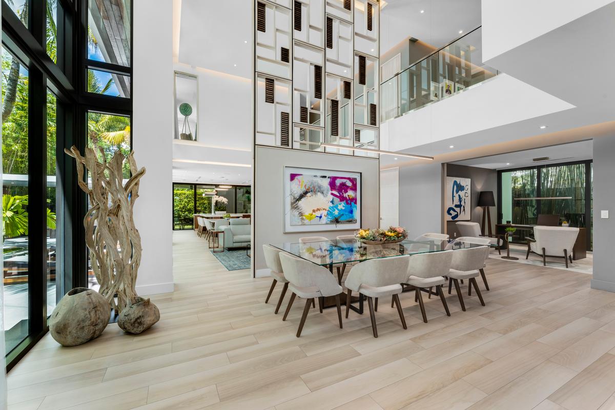 The ceiling soars high above the dining room and open floor plan main level, with a mezzanine area and bedrooms on the second level. (Courtesy of 1 Oak Studios/ONE Sotheby’s International Realty)