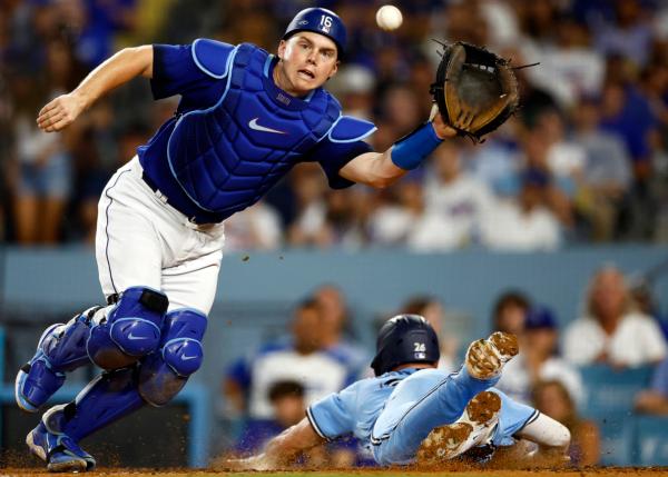 Matt Chapman (26) of the Toronto Blue Jays slides for a run past Will Smith (16) of the Los Angeles Dodgers in the eighth inning at Dodger Stadium in Los Angeles on July 25, 2023. (Ronald Martinez/Getty Images)