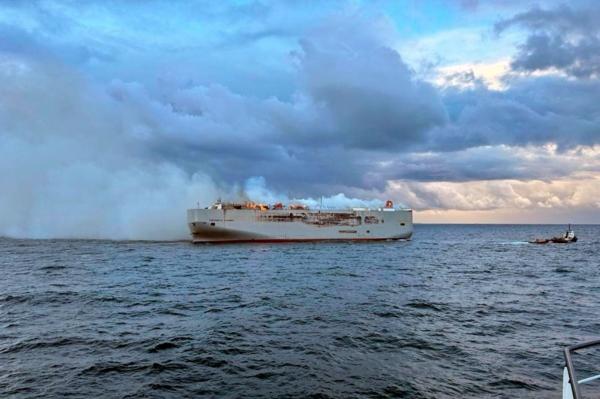 Smoke and flames are seen on a freight ship in the North Sea, about 27 kilometers (17 miles) north of the Dutch island of Ameland on July 26, 2023. (Kustwacht Nederland/Coastguard Netherlands via AP)