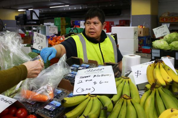 A store worker serves a customer at Paddy's Market in Sydney, Australia, on Oct. 22, 2022. (Lisa Maree Williams/Getty Images)