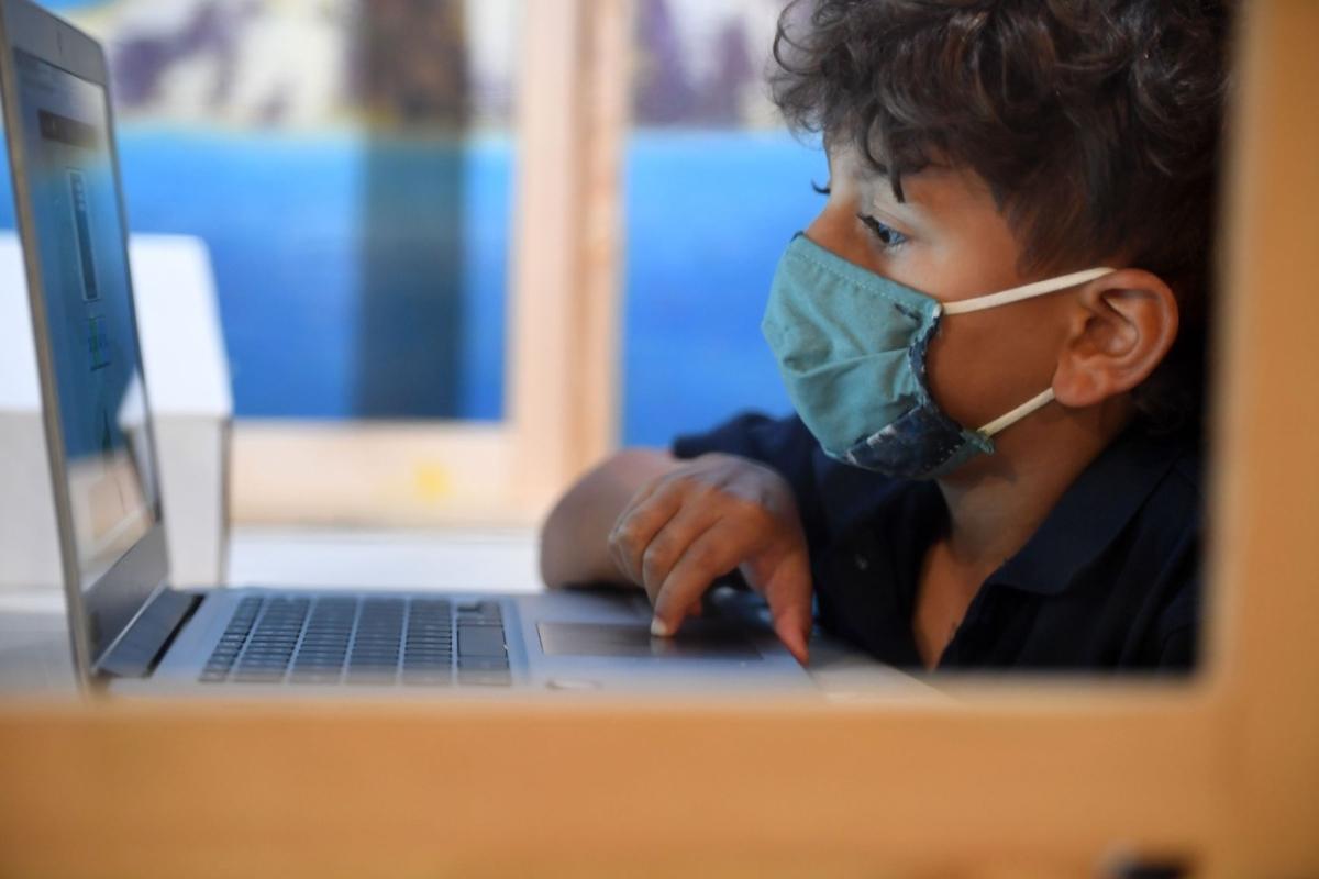 A student follows along remotely with a teacher's online live lesson at a desk separated from others by plastic barriers at STAR Eco Station Tutoring & Enrichment Center in Culver City, Calif., on Sept. 10, 2020. (Robyn Beck/AFP via Getty Images)