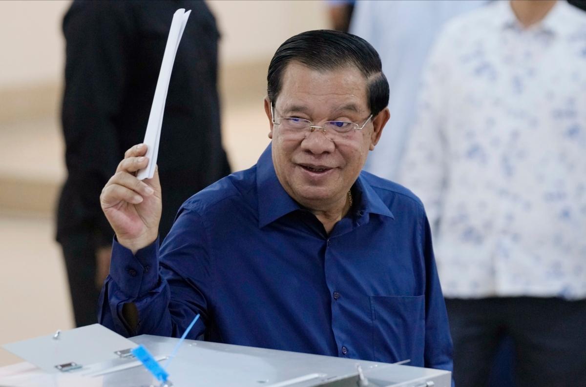 Cambodian Prime Minister Hun Sen of the Cambodian People's Party (CPP) raises a ballot before voting at a polling station at Takhmua in Kandal province, southeast Phnom Penh, Cambodia, on July 23, 2023. (Heng Sinith/AP Photo)