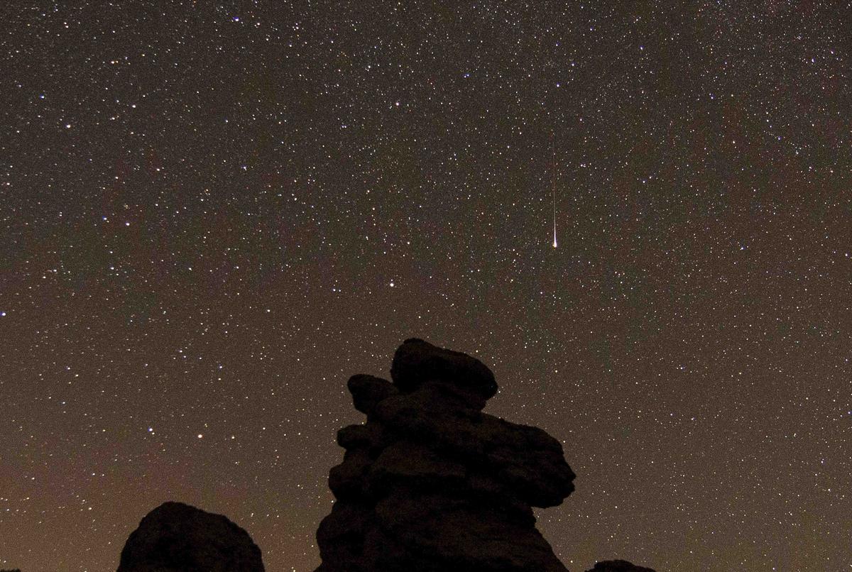 A Perseid meteor streaks over the stone dools near the village of Kuklica in the municipality of Kratovo, Northern Macedonia, an area of naturally formed stone pillars that resemble humans, on Aug. 13, 2021. (ROBERT ATANASOVSKI/AFP/Getty Images)