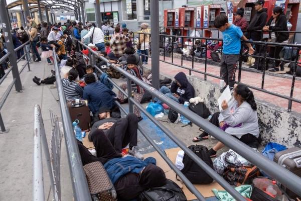 Migrants seeking asylum wait for U.S. Customs and Border Protection agents to allow them enter the United States at the San Ysidro crossing port on the US-Mexico border, as seen from Tijuana, Baja California state, Mexico on May 31, 2023. (Guillermo Arias/AFP via Getty Images)