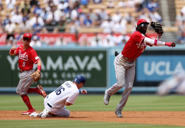 Elly De La Cruz (44) of the Cincinnati Reds turns a double play past a sliding Will Smith (16) of the Los Angeles Dodgers during the first inning at Dodger Stadium in Los Angeles on July 30, 2023. (Harry How/Getty Images)