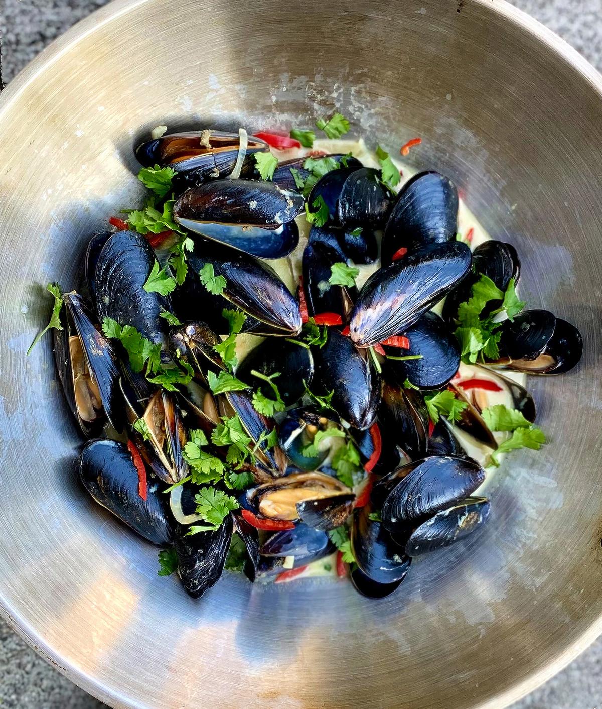 These Thai-style mussels are steamed in a heady concoction of coconut milk whisked with green curry paste and aromatics. (Lynda Balslev for Tastefood)