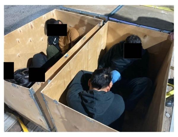 Migrants are hidden in wooden crates to be transported in this 2022 image. (Courtesy of Department of Justice)