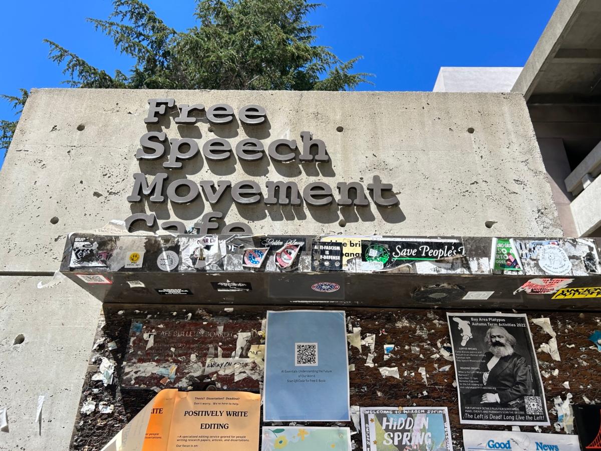 A flyer with an image of Karl Marx on a wall below the sign of the Free Speech Movement Cafe in Berkeley, Calif., on July 30, 2023. (Courtesy of Loretta Breuning)