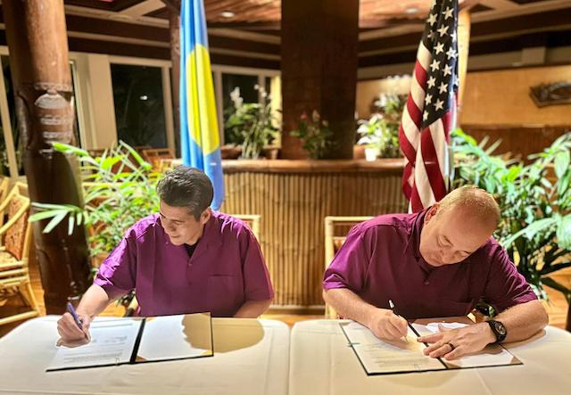 Republic of Palau President Surangel Whipps Jr., (L) and U.S. Coast Guard 14th District Commander Rear Adm. Michael Day sign an expanded bilateral law enforcement agreement on Aug. 23 during a Joint Heads of Pacific Security conference in Palau. (Courtesy U.S. Embassy)