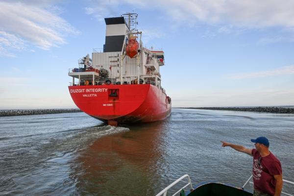 Romanian navigation personnel on a pilot vessel oversees a ship previously anchored on the Black Sea now entering the Sulina canal, one of the spilling points of the river Danube to the Black Sea in Sulina, Romania, on June 8, 2022. (Daniel Mihalescul/AFP via Getty Images)