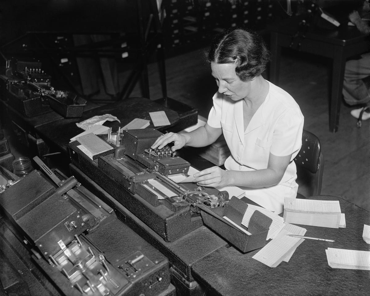 Social Security Administration clerk punching tabulator operation cards, with each hole representing a letter or a numbers. Ca. 1938. (Everett Collection/Shutterstock)