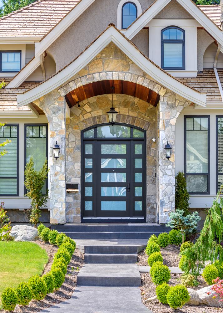 The design of the front door makes a statement, from the color to the woodworking and welcome mat.(karamysh/Shutterstock)