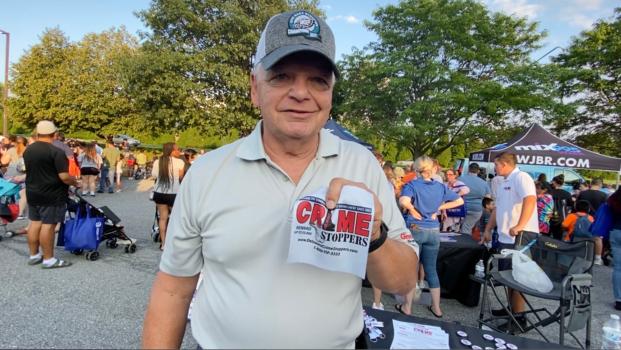 Charlie Manelski of Delaware Crimestoppers had a table at National Night Out in Newark on Aug. 1, 2023. (Lily Sun/The Epoch Times)