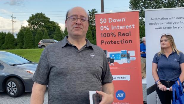  Adam Trungold, a solution advisor at ADT in New Castle, Del., had a table at National Night Out in Newark on Aug. 1, 2023. (Lily Sun/The Epoch Times)