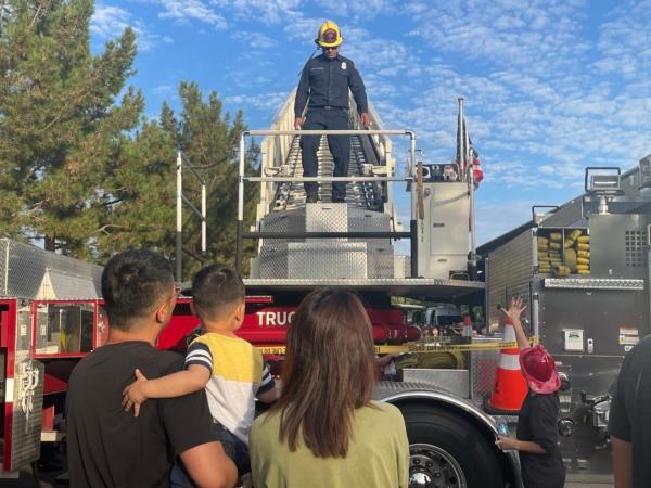 Firefighters from Orange County Fire Authority conduct ladder demonstration to families at the "National Night Out" at Woodbury Community Park in Irvine, Calif., on Aug. 1, 2023. (Carol Cassis/The Epoch Times)