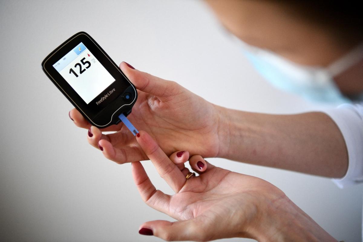 A woman with diabetes uses a glucometer to measure the glycemia in her blood in Paris on March 24, 2020. (Franck Fife/AFP via Getty Images)