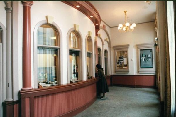 Once inside the doors, guests are treated to an architectural look that mirrors what was established outside in 1871. The curved box office features faux columns, arched ticket windows, and the same glass-globe brass chandeliers that are present in the main auditorium. Performance posters are featured in glassed, corniced cases. (Courtesy of TheGrandWilmington)