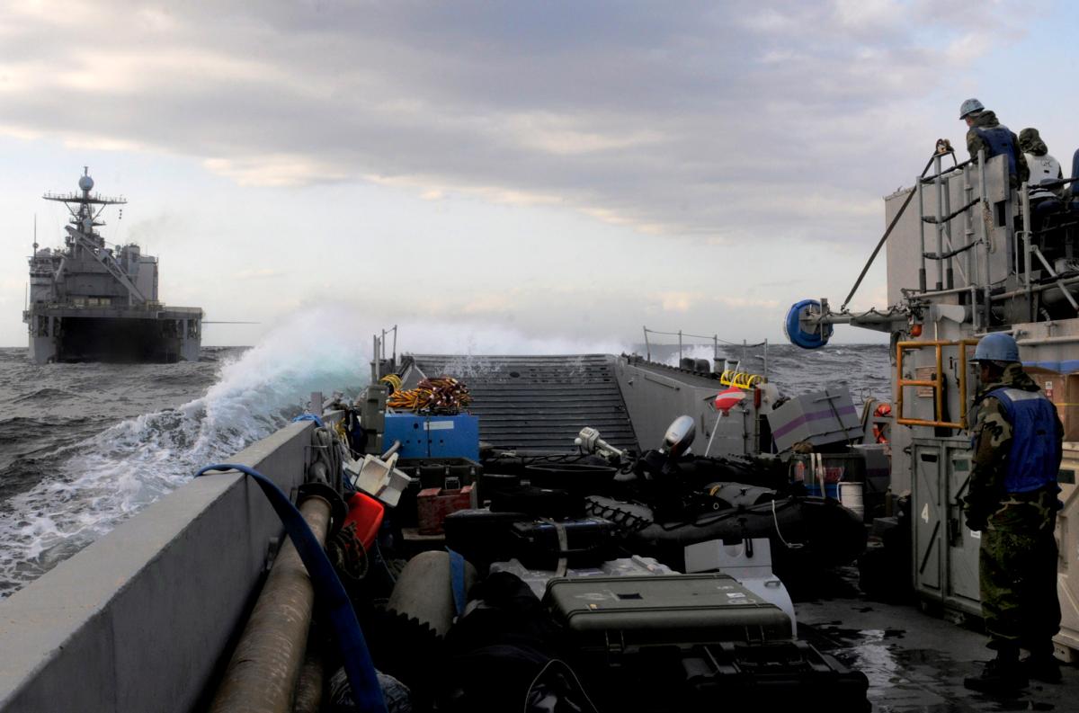 Sailors embarked aboard the amphibious transport dock ship USS Tortuga, piloting a landing craft toward the well-deck after the ship transferred heavy equipment to USS Essex at sea in the Pacific Ocean, on April 2, 2011. (Mass Communication Specialist 1st Class Josh Huebner/U.S. Navy via Getty Images)