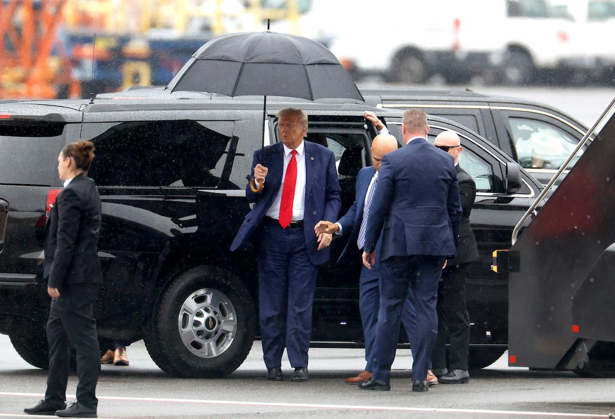  Former President Donald Trump holds an umbrella as he arrives at Reagan National Airport following an arraignment in a Washington, D.C., court in Arlington, Va., on Aug. 3, 2023. (Tasos Katopodis/Getty Images)