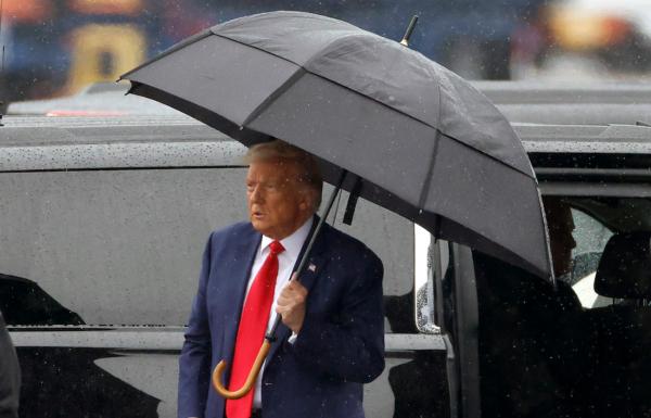 Former President Donald Trump holds an umbrella as he arrives at Reagan National Airport following an arraignment in a Washington court in Arlington, Va., on Aug. 3, 2023. (Tasos Katopodis/Getty Images)