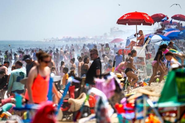 A lifeguard drinks water from under an umbrella at Rehoboth Beach, Del., on July 28, 2023. (JIM WATSON/AFP via Getty Images)