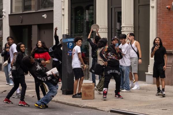 A group of young people film themselves as they throw ceramic plates at police officers during riots, after Twitch streamer Kai Cenat announced a "giveaway" event in New York's Union Square on Aug. 4, 2023. (Yuki Iwamura/AFP via Getty Images)