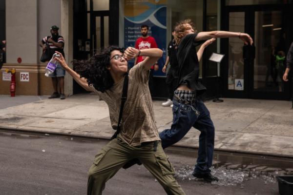 People throw ceramic plates and water bottles at police officers during after Twitch streamer Kai Cenat announced a "givaway" event,in New York's Union Square on Aug. 4, 2023. (Yuki Iwamura/AFP via Getty Images)
