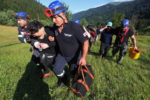 Rescuers evacuate people from the area affected by a landslide in the Racha Region, Georgia, on Aug. 4, 2023. (Irakli Gedenidze/Reuters)